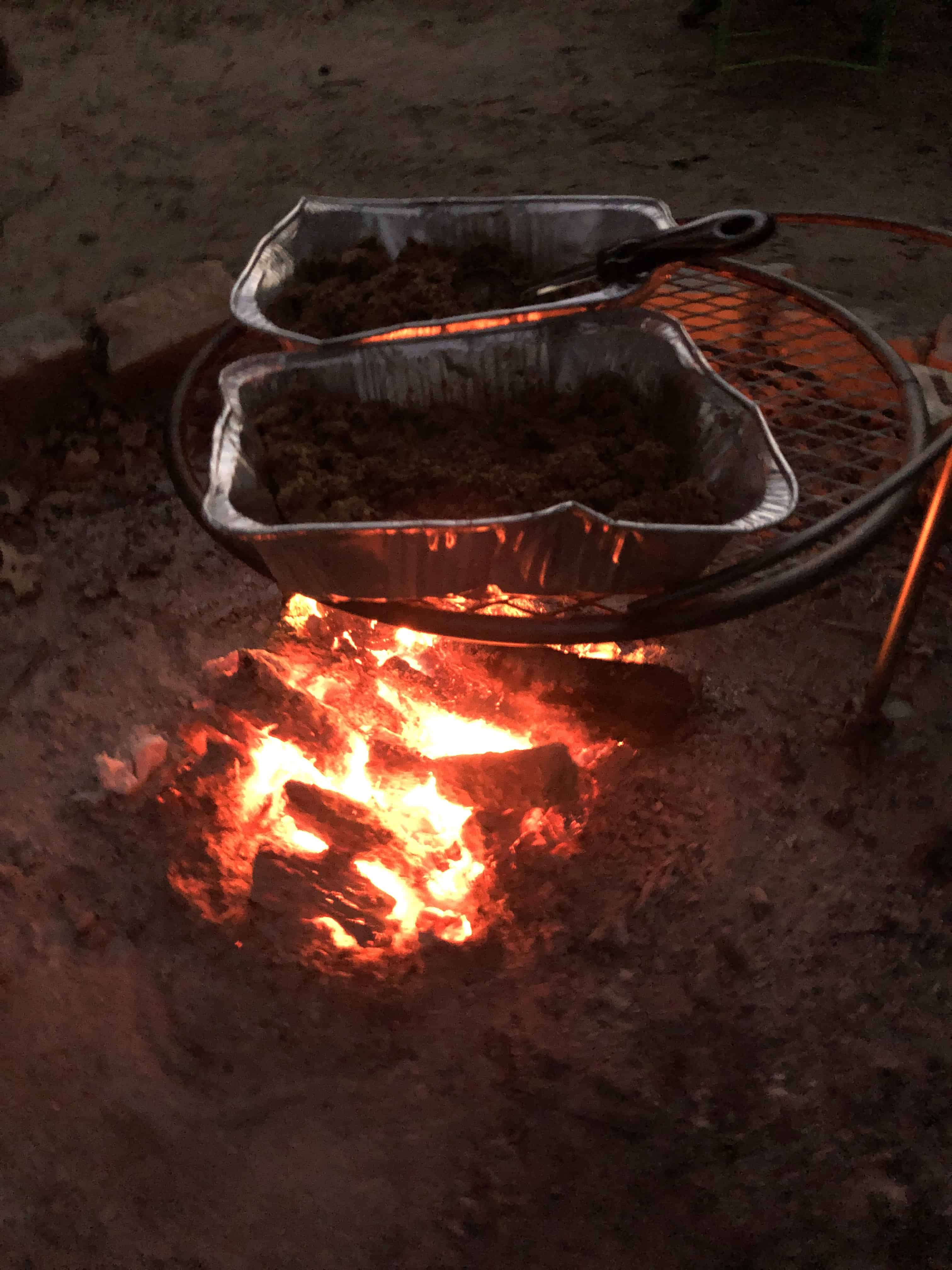 Photograph of warming taco meat over a campfire