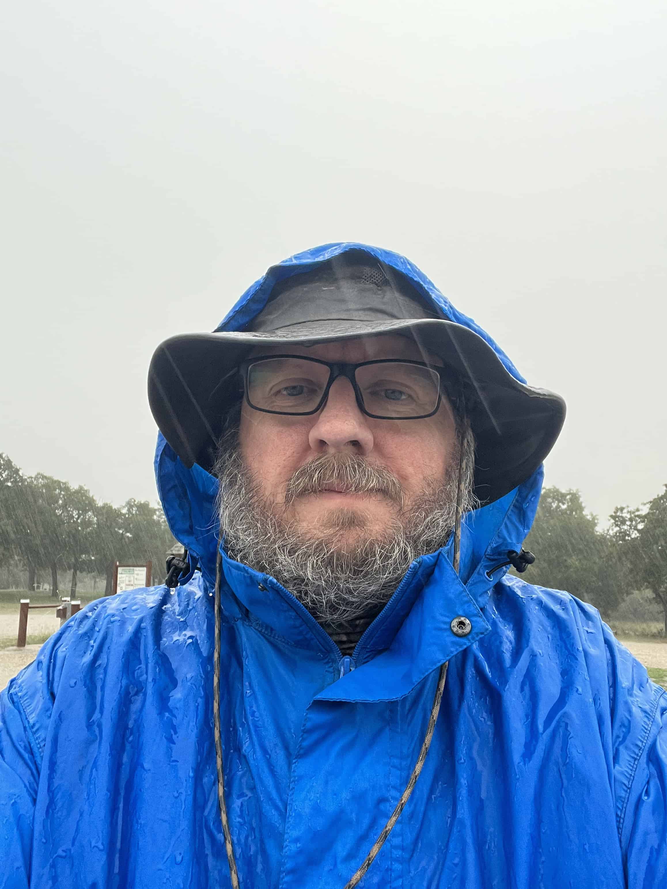 Photograph of Mark Wilcox dressed in a camping rain suit