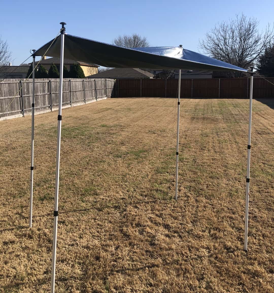 A tarp tied to extendable tent poles to create a canopy.